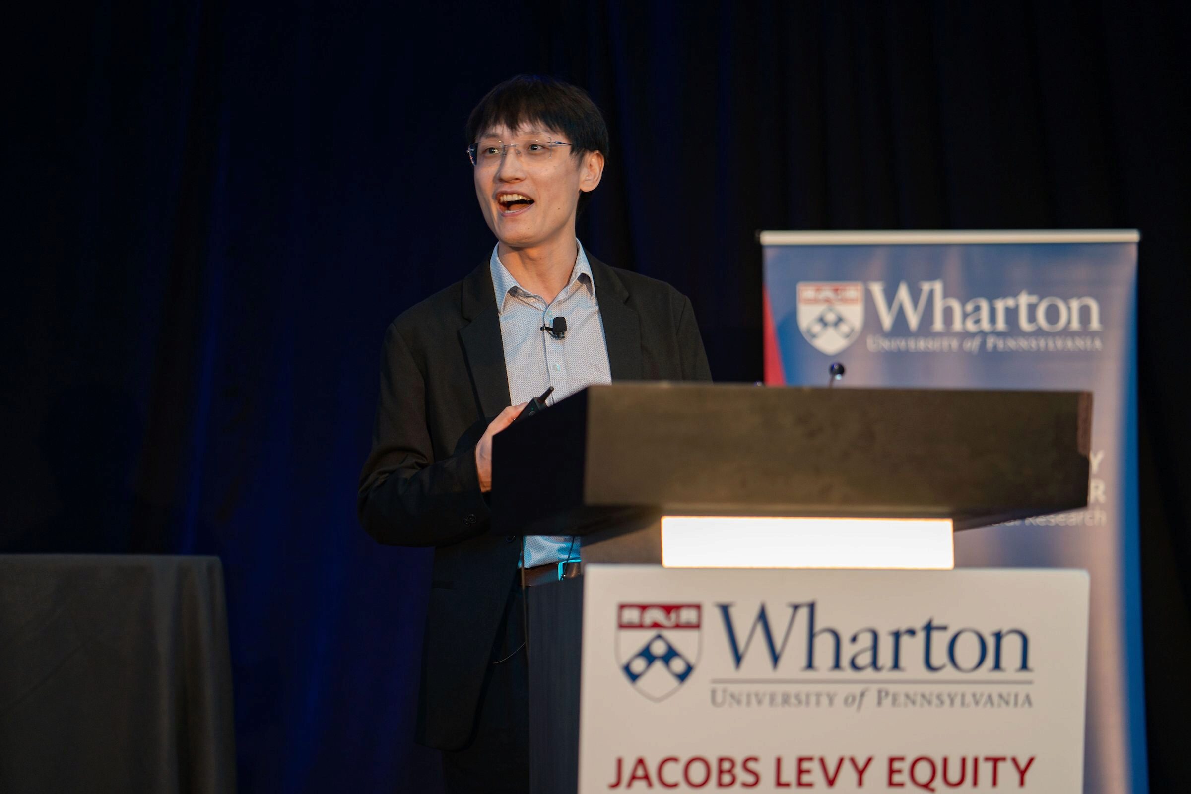 Yao Zeng speaking at a Wharton podium