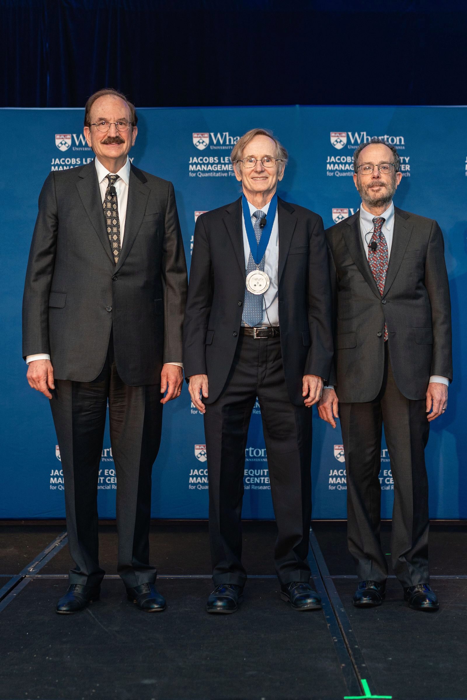 Albert S. “Pete” Kyle stands wearing the Jacobs Levy medal between Bruce Jacobs and Ken Levy