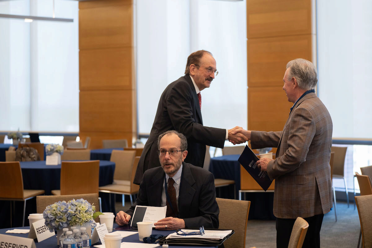 Bruce Jacobs shakes hands with a conference attendee.