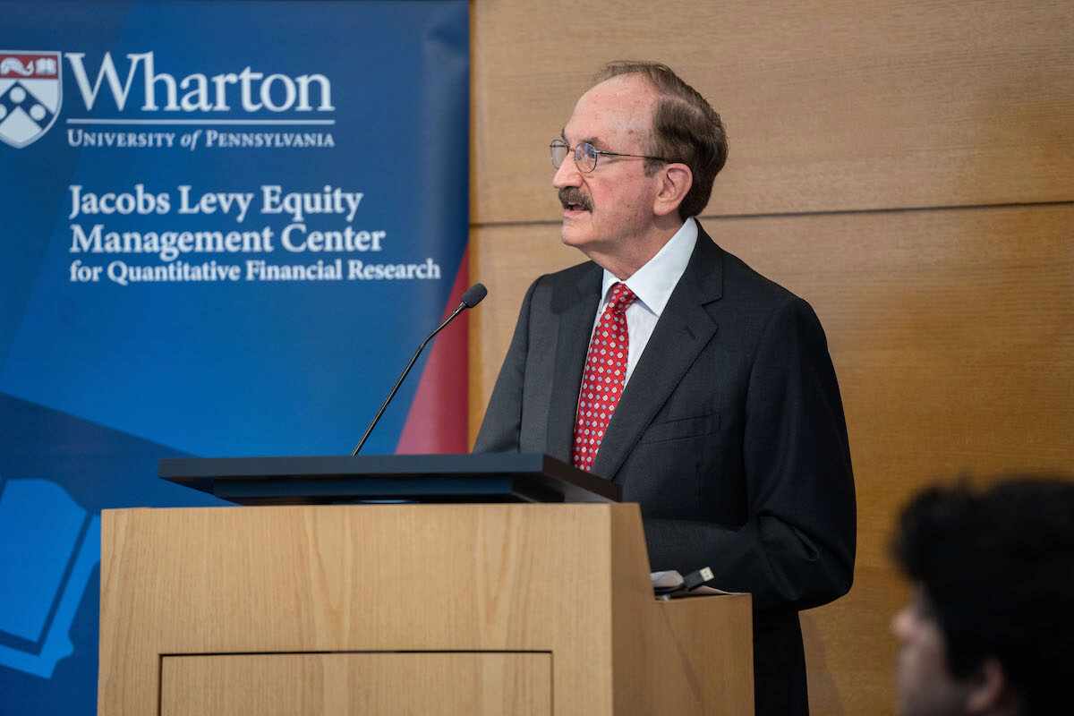 Bruce Jacobs speaks at a podium during the 2024 Frontiers in Quantitative Finance Conference