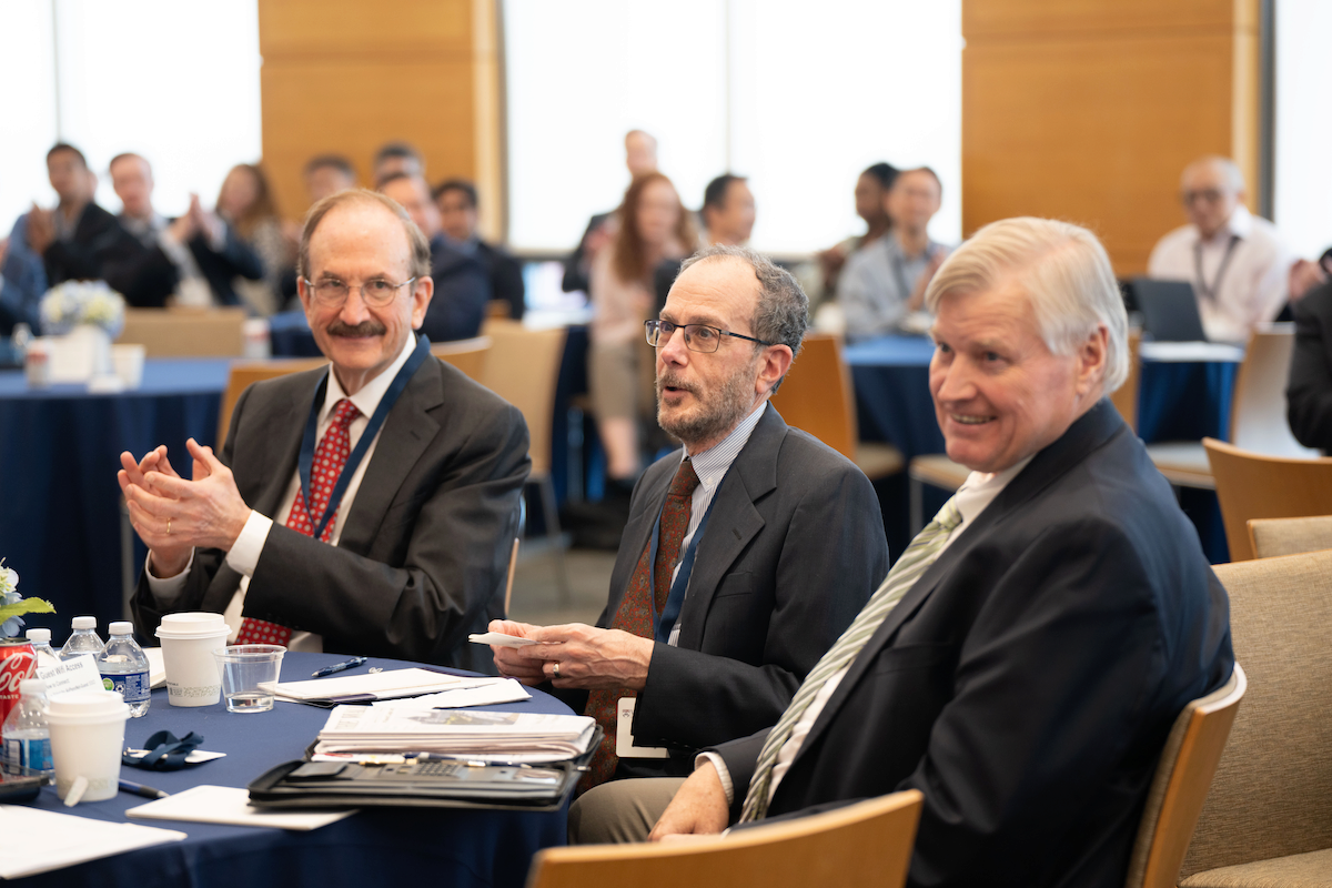 Bruce Jacobs, Ken Levy, and Craig MacKinlay sit together at the conference.