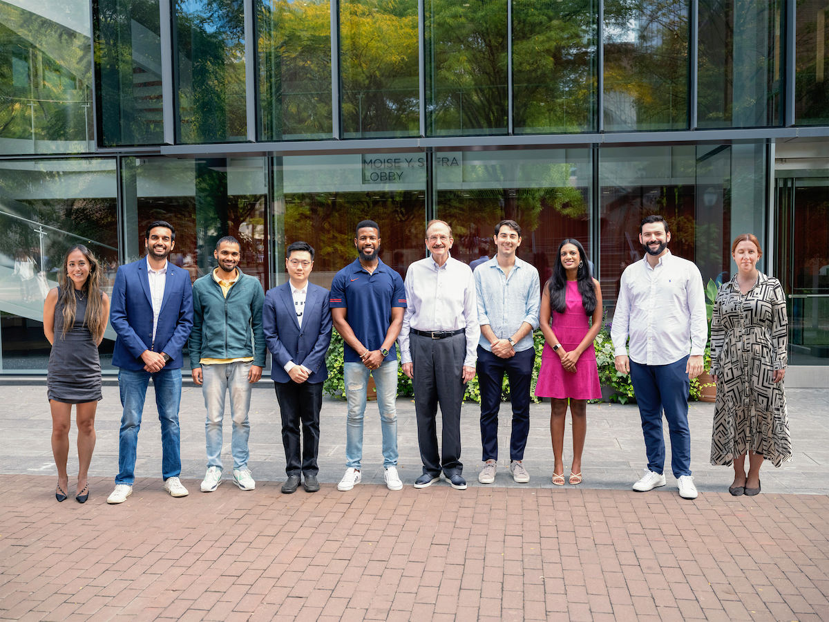 The Jacobs Scholars pose for a photo outdoors with Bruce Jacobs