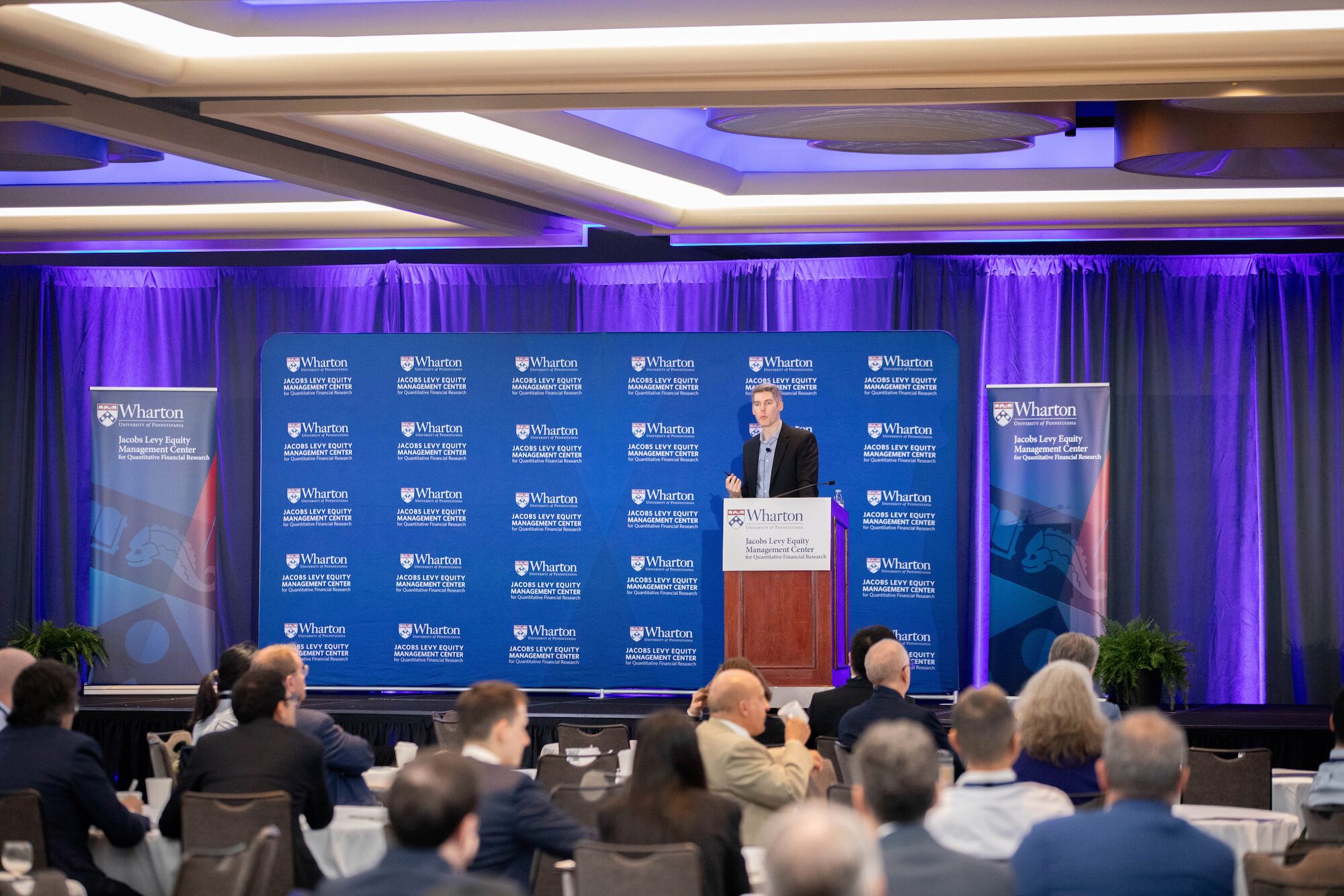 A speaker at a podium before an audience