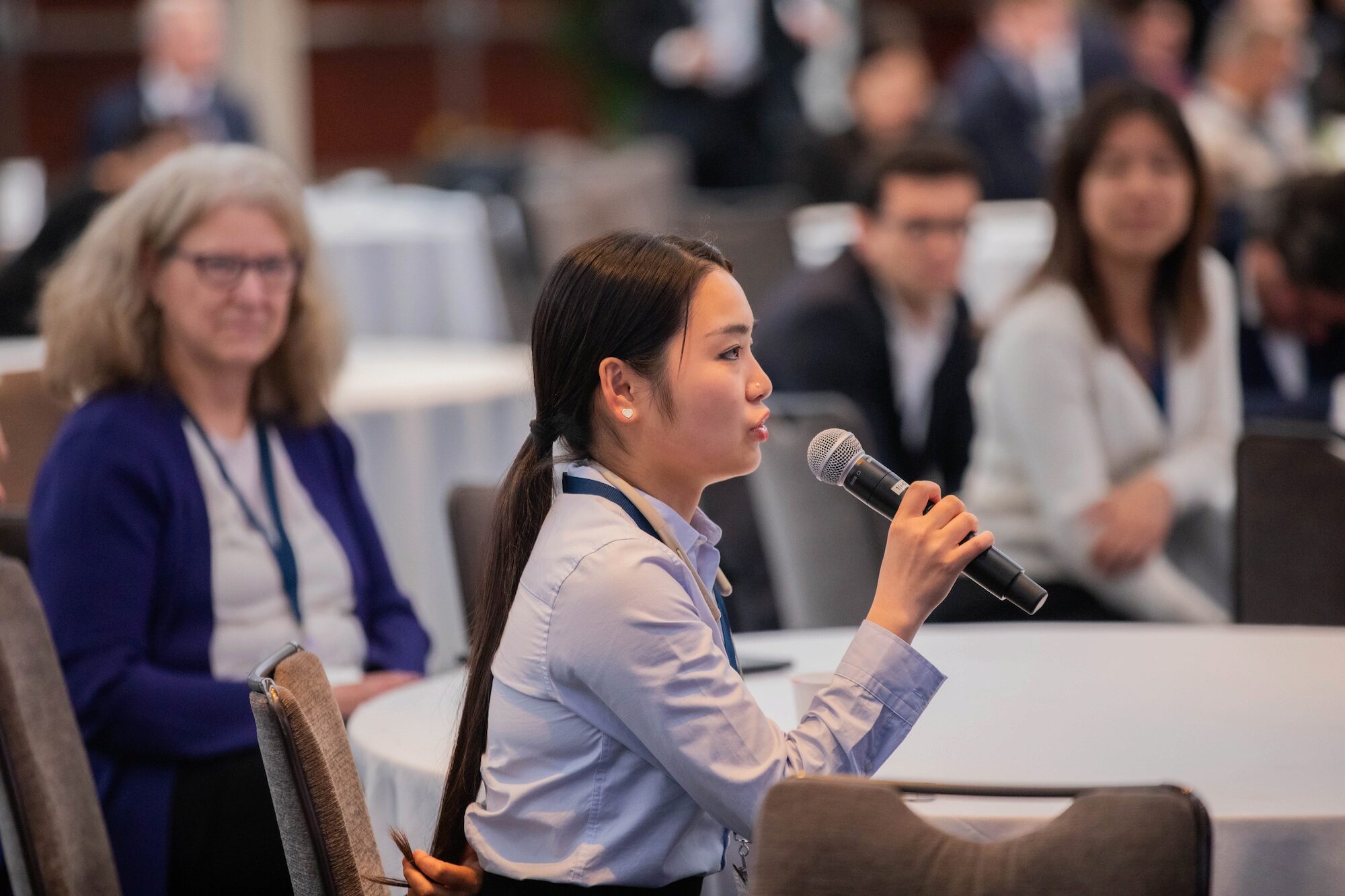 An audience member at a conference speaks into a microphone