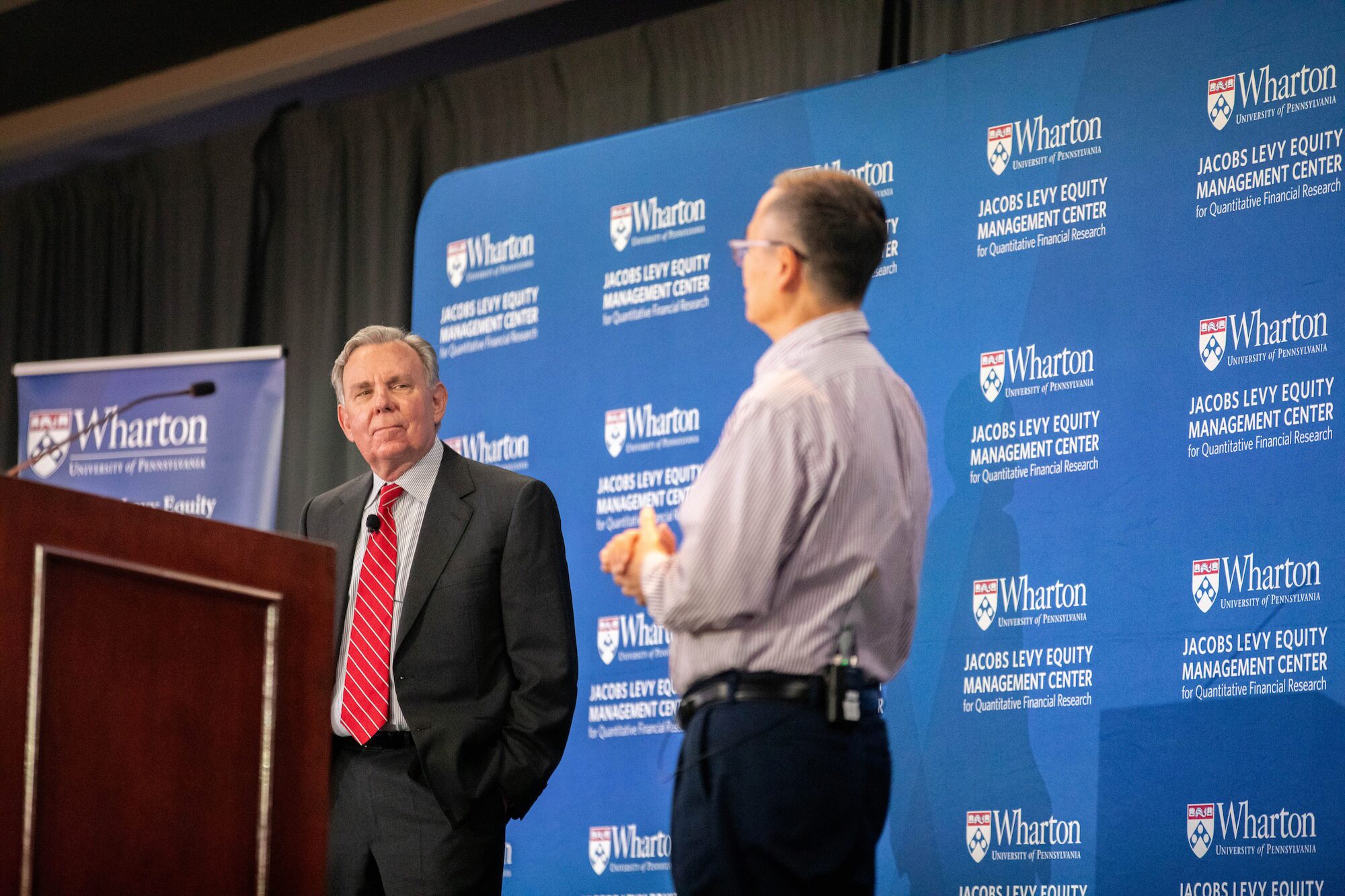 Two speakers in conversation onstage at a podium