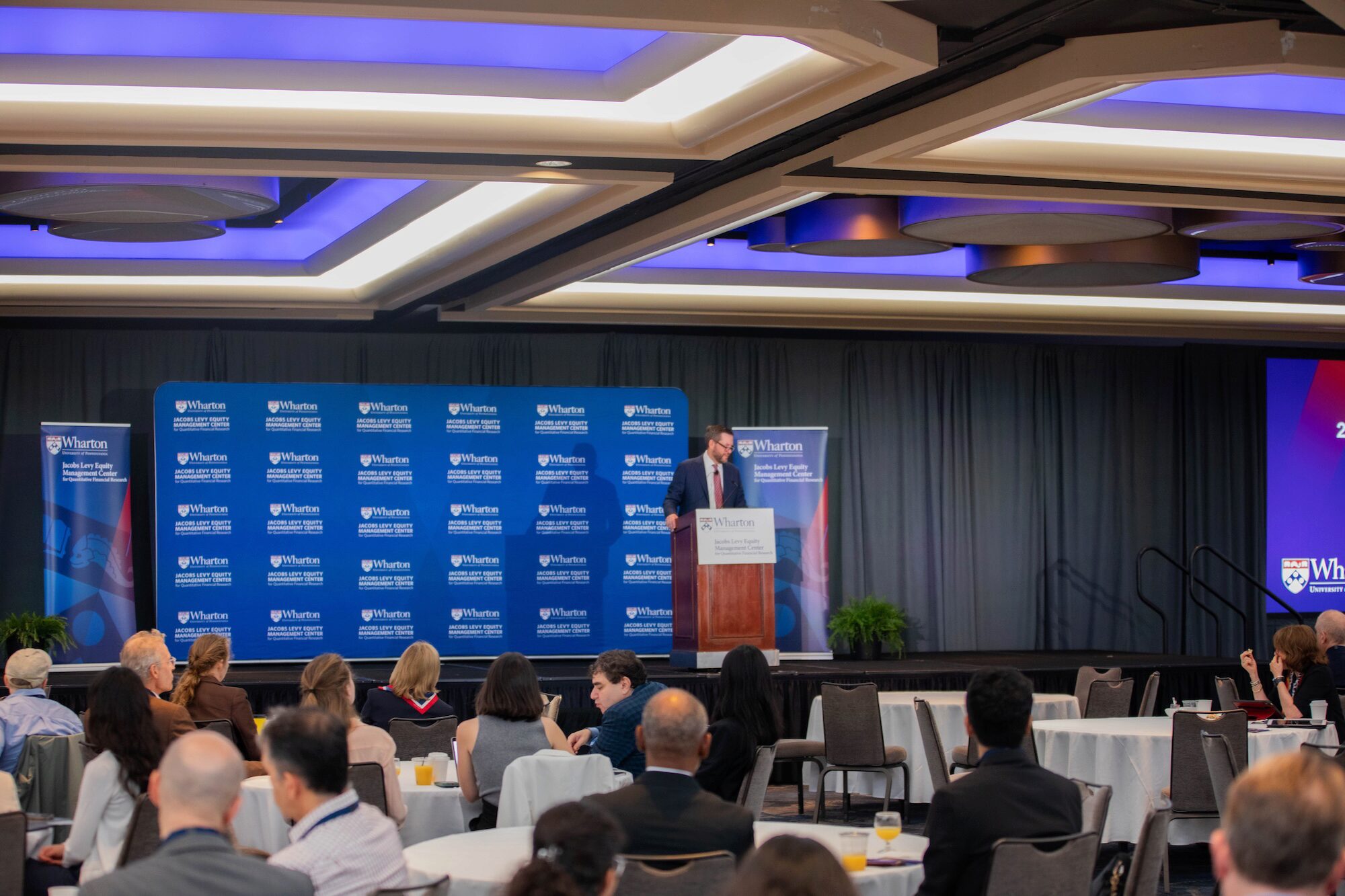 A speaker at a podium before an engaged audience